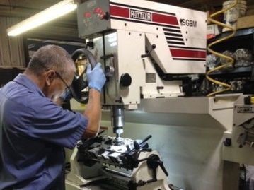 man with glasses fixing cylinder heads